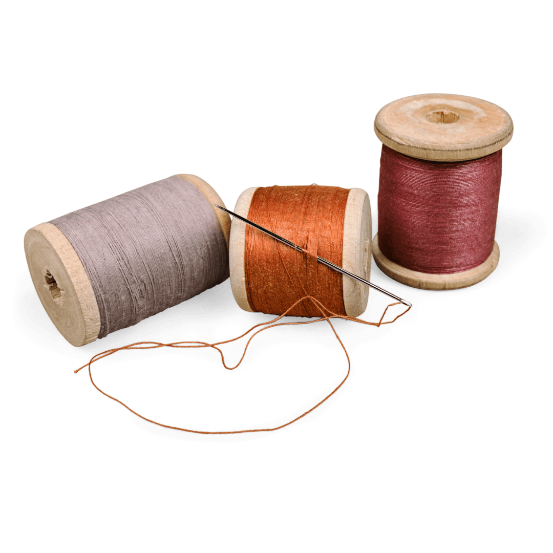 Varios hilos de coser de diferentes colores y aguja